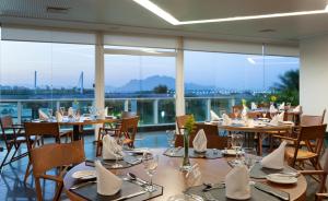 a restaurant with tables and chairs and large windows at Hotel Senac Ilha do Boi in Vitória
