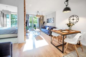 a living room and dining room with a table and chairs at Apartament AP30 in Mielno