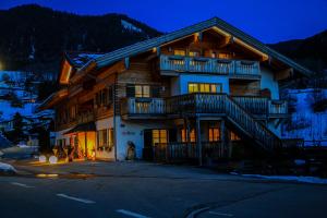 a large wooden house with balconies on the side of it at Alpinhotel Berchtesgaden in Berchtesgaden