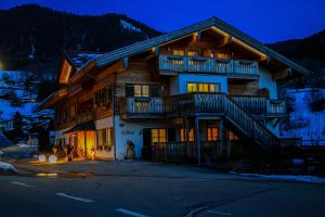 Una gran casa de madera con balcones en un lateral. en Alpinhotel Berchtesgaden, en Berchtesgaden