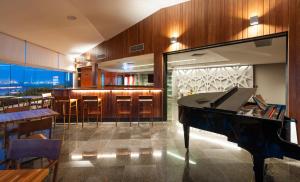 a restaurant with a piano and a bar at Hotel Senac Ilha do Boi in Vitória