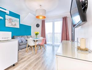 a kitchen and living room with a couch and a table at Apartamenty Olivia in Władysławowo