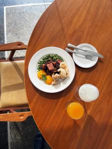 a plate of food on a wooden table at Hotel Senac Ilha do Boi in Vitória
