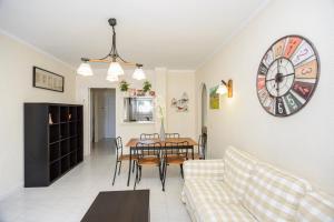a living room with a table and a clock on the wall at Sant Mori in Empuriabrava +29 photos