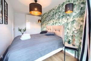 a bedroom with a large bed with blue sheets at Apartament AP4 in Mielno