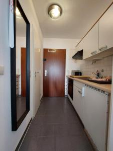 シュタインフーデにあるFerienwohnung Resit 3の白いキャビネットと茶色のドア付きのキッチン