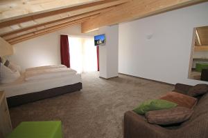 uma sala de estar com uma cama e um sofá em Alpinhotel Berchtesgaden em Berchtesgaden
