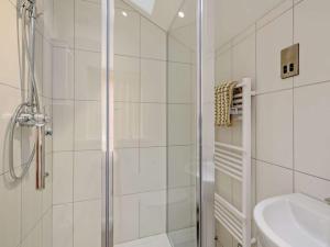 La salle de bains blanche est pourvue d'une douche et d'un lavabo. dans l'établissement The White Lady, à Worstead