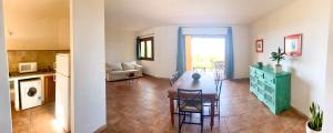 a kitchen and a dining room with a table in a room at Sunrise 14 in San Pantaleo