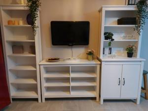 salon z telewizorem i białymi półkami w obiekcie Bungalow Playmar Maspalomas w mieście Maspalomas