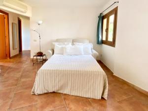 a bedroom with a large bed with white pillows at Sunrise 14 in San Pantaleo