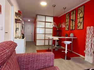 una sala de estar con paredes rojas y una mesa. en Apartamento Centro Frente Muralla 2, en Lugo