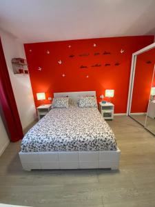 um quarto com uma cama e uma parede vermelha em Apartamento Centro Frente Muralla 2 em Lugo