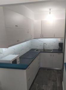 a kitchen with white cabinets and a blue counter top at apartment in a country house# in Kalamata