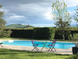Sainte-Agathe-la-Bouteresse的住宿－Domaine du Perrier，游泳池畔的两把椅子和一张桌子