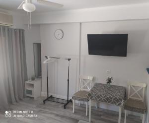 Cette chambre dispose d'une table, de deux chaises et d'une télévision. dans l'établissement apartment in a country house#, à Kalamata