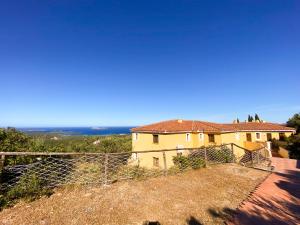 a house on a hill with the ocean in the background at Sunrise 14 in San Pantaleo