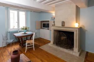 a living room with a table and a fireplace at LES URSULINES Centre Historique de BAYEUX in Bayeux +17 photos