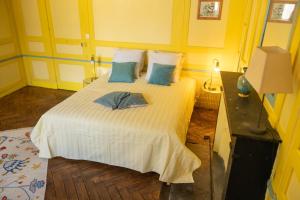 a bedroom with a white bed with blue pillows at LES URSULINES Centre Historique de BAYEUX in Bayeux