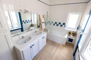 a bathroom with two sinks and a tub and a mirror at LES URSULINES Centre Historique de BAYEUX in Bayeux