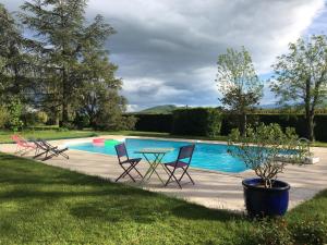 a patio with a table and chairs next to a pool at Domaine du Perrier in Sainte-Agathe-la-Bouteresse