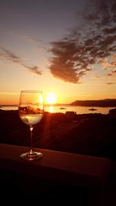 a glass of wine sitting on a table in front of the sunset at Apartments Nika in Cavtat