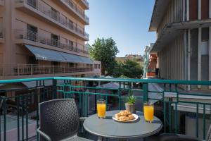 a table with a plate of food and two glasses of orange juice at MIRMA CITY Old Town in Chania