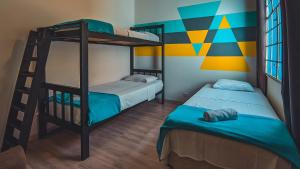 two bunk beds in a room with a mural at Social Hostel Café e Bar in Curitiba
