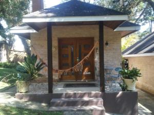 a gazebo with a hammock in front of a house at Estalagem Monte Verde in Monte Verde