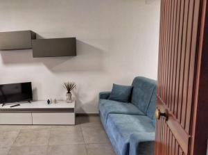 a living room with a blue couch and a tv at Casa Spinuzza 4 in Cefalù