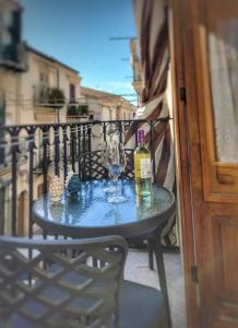 een tafel met twee flessen en twee glazen op een balkon bij Casa Spinuzza 4 in Cefalù