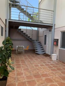 un patio con escalera, mesa y silla en Marion Apartments, en Kourouta