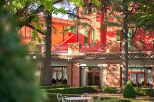 a building with a table and chairs in front of it at Hotel Villa Il Patriarca in Chiusi
