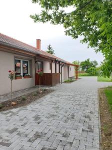 a brick driveway in front of a house at Kajári Apartmanház in Balatonfőkajár