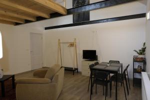 a living room with a table and a chair and a television at Kajári Apartmanház in Balatonfőkajár