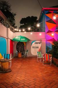 a patio with chairs and an umbrella at night at Social Hostel Café e Bar in Curitiba