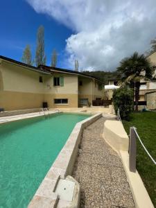 a swimming pool in front of a house at Hôtel Le Moulin D'Olt in La Canourgue