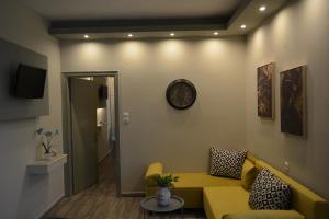 uma sala de estar com um sofá amarelo e uma televisão em Villa Georgio Paralia em Paralia Katerinis