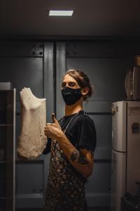 a woman wearing a mask holding a bag of dough at Social Hostel Café e Bar in Curitiba
