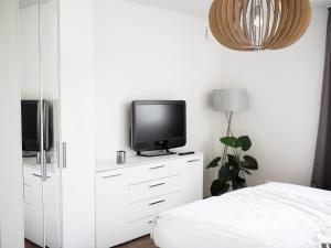 a bedroom with a bed and a tv on a dresser at Moderne Ferienwohnung mit Seeblick & Terrasse 96qm in Großräschen