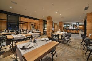 a dining room with tables and chairs and a restaurant at Hotel Astoria in Livigno