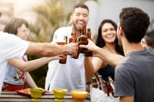 a group of people drinking beer at a table at Social Hostel Café e Bar in Curitiba