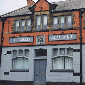 un edificio con un cartel para el bar louvinyslibrary en The Vaults en Wrexham