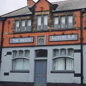 a building with a sign for the louvinyslibrary bar at The Vaults in Wrexham