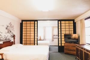 a hotel room with two beds and a television at Royal Grove Waikiki in Honolulu