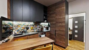 a kitchen with wooden cabinets and a counter top at The Hideout in Žilina