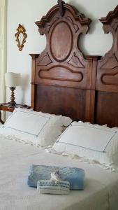 a bed with a large wooden headboard with a pillow on it at B&B La casa del mugnaio di Capriata d'Orba in Predosa
