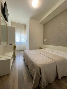 een slaapkamer met een bed en een televisie. bij Hotel Cristina in Lido di Jesolo