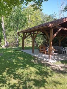 a wooden pavilion with a picnic table in a park at Víz-Party vendégház in Dunasziget