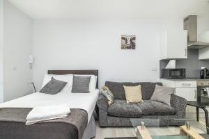 a bedroom with a bed and a couch at Securematics Kings Studio Apartments in London